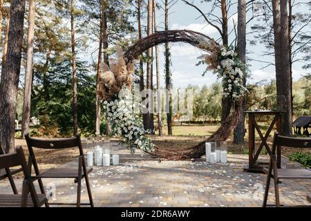 Wedding Ceremony Arch decoreted with Flower Arrangements on the trees background Stock Photo