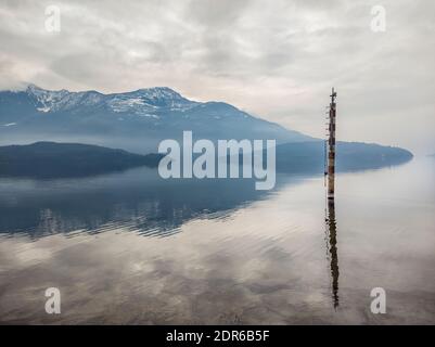 Mooring pole on lake como in a winter morning