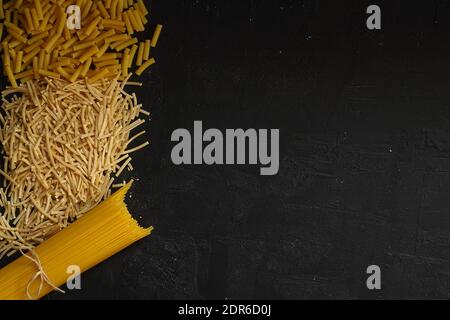 Italian pasta panorama, a flat lay of various sorts of pasta, top shot on a black background Stock Photo