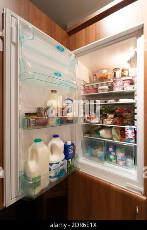 UK fridge or refrigerator with door open showing contents inside. Stocked up, supplies, provisions, food, fridge items, perishables Stock Photo
