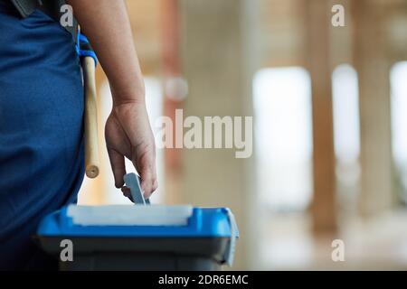 Close up of unrecognizable female worker carrying toolbox while walking on construction site, copy space Stock Photo