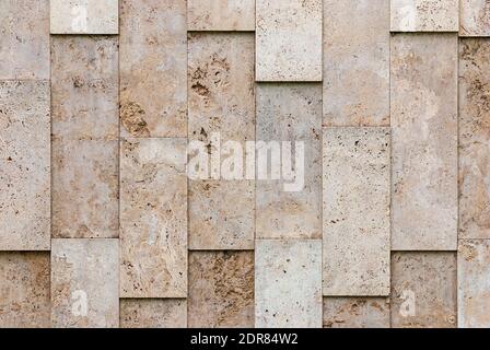 beige-gray wall of natural textured stone blocks, irregularly arranged Stock Photo