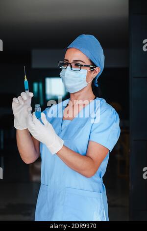 Latin woman doctor holding vaccine injection for coronavirus covid 19 World immunization in Latin America pandemic Stock Photo