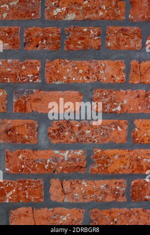 Full frame texture background of a shabby chic old red brick wall with an attractive weathered patina, and thick dark gray mortar Stock Photo