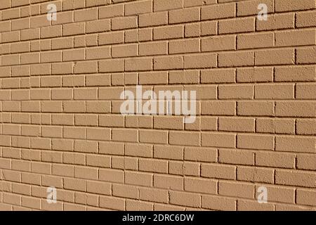 Full frame texture background of a textured beige painted exterior brick wall surface with a mild grungy look for normal weathering Stock Photo
