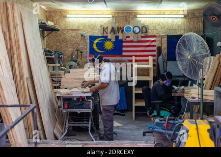 (201221) -- KUALA LUMPUR, Dec. 21, 2020 (Xinhua) -- Workers are busy at Kawood workshop on the suburbs of Kuala Lumpur, Malaysia, Dec. 17, 2020. Mohamad Hafiz Johari, together with two other former photographers Abdul Razak Abdul Latif and Noor Adzrene Mohd Noor, came together to set up Kawood, a combination of the Malay word kawan (friend) and wood, with all three having lost their source of income due to disruptions caused by the COVID-19 pandemic. Undeterred, they brainstormed some means of making a living, ultimately deciding on putting their enthusiasm for construction into building and Stock Photo