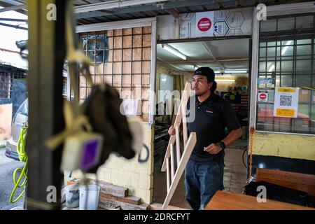 (201221) -- KUALA LUMPUR, Dec. 21, 2020 (Xinhua) -- Abdul Razak Abdul Latif delivers a product to his customer at Kawood workshop on the suburbs of Kuala Lumpur, Malaysia, Dec. 18, 2020. Mohamad Hafiz Johari, together with two other former photographers Abdul Razak Abdul Latif and Noor Adzrene Mohd Noor, came together to set up Kawood, a combination of the Malay word kawan (friend) and wood, with all three having lost their source of income due to disruptions caused by the COVID-19 pandemic. Undeterred, they brainstormed some means of making a living, ultimately deciding on putting their enth Stock Photo