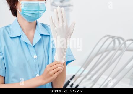 Nurse putting on rubber glove Stock Photo