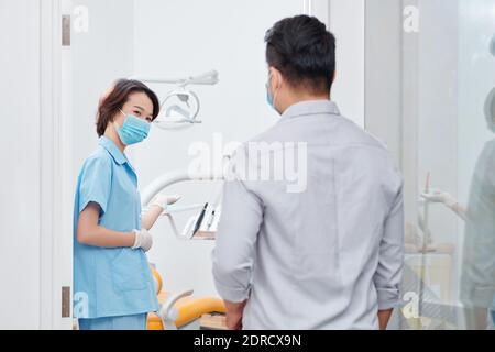 Dental nurse inviting patient Stock Photo