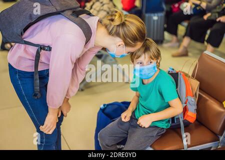 Mother and son travelers with medical face mask to protection the coronavirus in airport Stock Photo