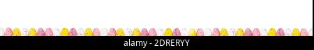 Amazing easter border with small colourful eggs isolated on white. Panorama paint eggs. Yellow, pink, white eggs in easter composition. Stock Photo