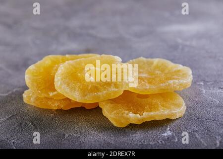 Yellow candied pineapple rings on a gray concrete background. Color trend 2021 Stock Photo