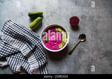 Beetroot dip and cucumber slices in a bowl on a background Stock Photo