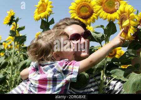 Mother with baby son in sunflower field Stock Photo - Alamy