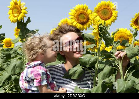Mother with baby son in sunflower field Stock Photo - Alamy