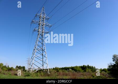 High voltage power line support against blue sky background. Electrical industry. Stock Photo