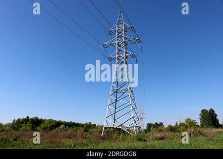 High voltage power line support against blue sky background. Electrical industry. Stock Photo