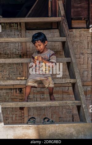 May 4, 2014. Rantepao, Tana Toraja, Sulawesi, Indonesia. Young boy at his house entrance. Stock Photo