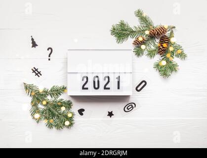 New Year or Christmas layout with numbers 2021. Lightbox with symbols of the year and New Year's toys on a white festive Christmas background Stock Photo