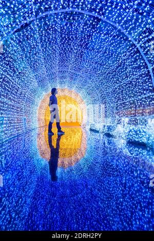 The man standing with blue lighting tunnel with reflection on ground Stock Photo