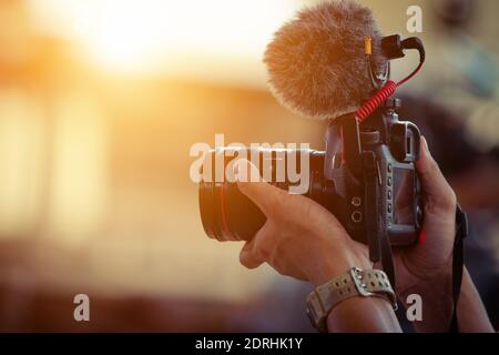 Blogger content creator camera handheld shooting video footage Stock Photo