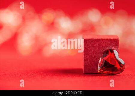 Empty podium for your products with a heart on a red background with bokeh. Concept of valentine's day, love. Copy space Stock Photo
