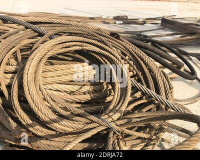 Coiled steel cables of lifting machinery. Crane parts at outdoor warehouse Stock Photo