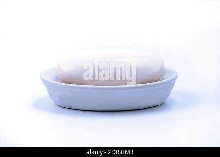 White natural Bar soap in a soap dish isolated on white background Stock Photo