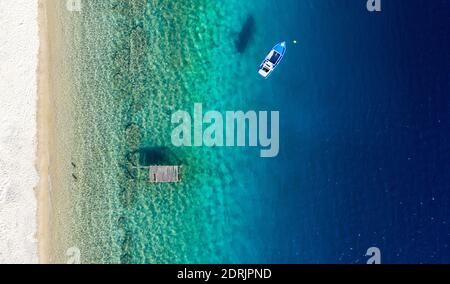 Aerial panorama of Mediterranean sea coast with white sand beach and blue water. Top view of sail boat and pier with copy space tropical summer backgr Stock Photo