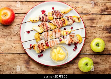 Barbecue turkey shish kebab with apple on rustic wooden table Stock Photo