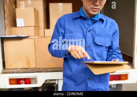 Serious courier with digital tablet Stock Photo