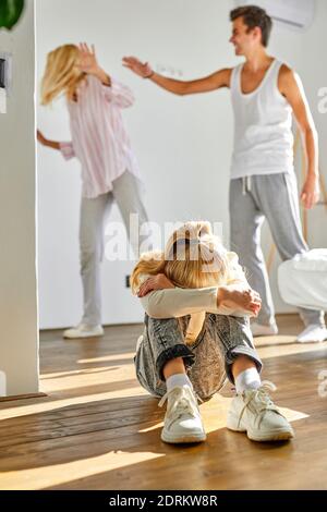 child is tired of family conflicts,divorce and children concept. little kid girl is upset with quarrelling of parents, they are going to be divorced Stock Photo