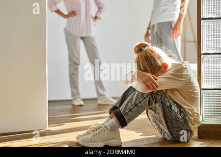 child girl is tired of family conflicts,divorce and children concept. little kid girl is upset with quarrelling of parents, they are going to be divor Stock Photo