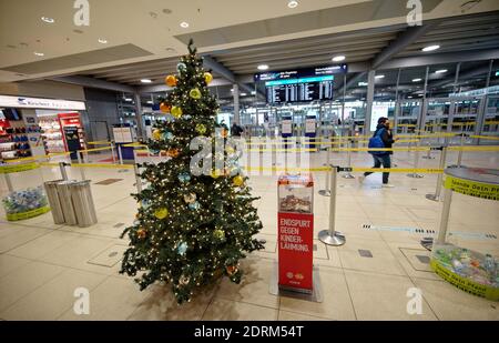 Cologne, Germany. 21st Dec, 2020. A Christmas tree stands in front of the security gate in Terminal 1 of Cologne/Bonn Airport. Only a few flights land and take off in the days before Christmas. Credit: Henning Kaiser/dpa/Alamy Live News Stock Photo