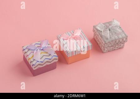 Three tiny gift boxes on pink background Stock Photo