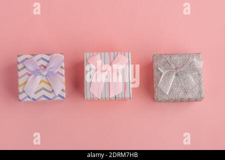 Three little gift boxes on pink background, top view Stock Photo