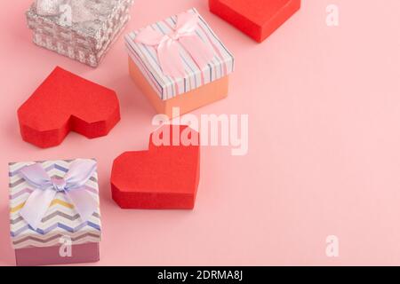 Small gift boxes and red paper boxes on pink background Stock Photo