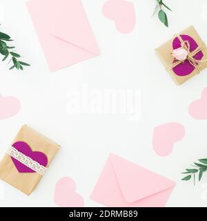 Valentines day. Frame with gifts, pink envelope and eucalyptus isolated on white background. Flat lay, top view Stock Photo