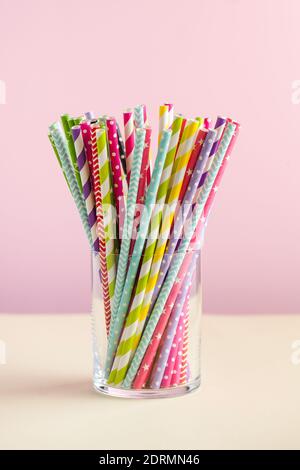Colorful paper tubes for drinks in a glass on colored backgrounds. The concept of party, celebration, birthday.  Stock Photo