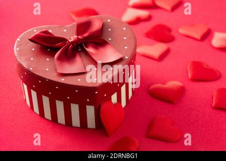 Gift box with heart shape and hearts on red background. Stock Photo
