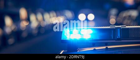 Siren light on roof of police car at street. Themes crime and emergency panoramic banner. Stock Photo