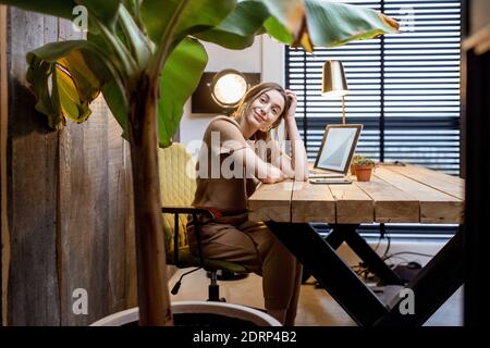 Portrait of a young woman in domestic suit at the beautiful and cozy home office Stock Photo