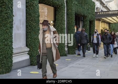 LONDON, UNITED KINGDOM - Dec 17, 2020: London, England - December 17th 2020: Festive decoration on Oxford Street. People wearing face masks while walk Stock Photo