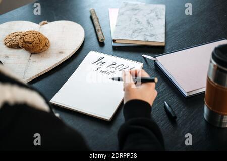 2021 goals, new year resolution, new me, start planning new year, 2021 is Coming. Female hand with Open notepad with text ready for planning on table Stock Photo