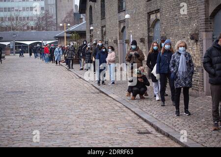 People waiting in line queued up for health screening for Coronavirus Covid-19 testing at city test center wearing medical protective mask. Copenhagen Stock Photo
