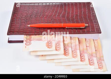 Close-up: leather diary with bookmarks out of money and fountain pen  Office supplies and . Stock Photo