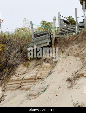 Erosion damaged wooden staircase built on the sandy edge of Lake Michigan Stock Photo