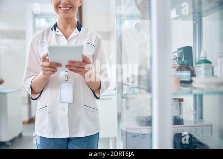 Merry female doctor using touchpad at work Stock Photo