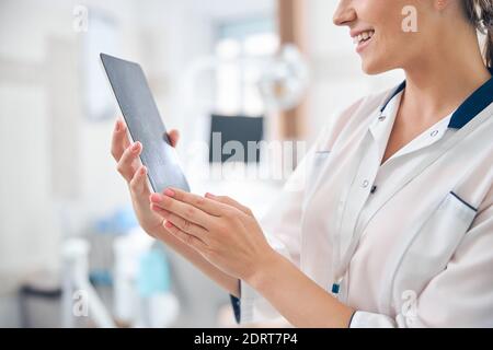Smiling female dentist using touchpad at work Stock Photo