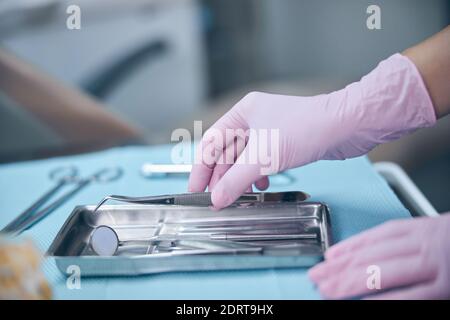 Female dentist using sterile instruments during treatment Stock Photo